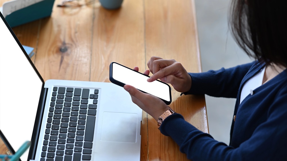 kobieta korzystająca z telefonu i laptopa
