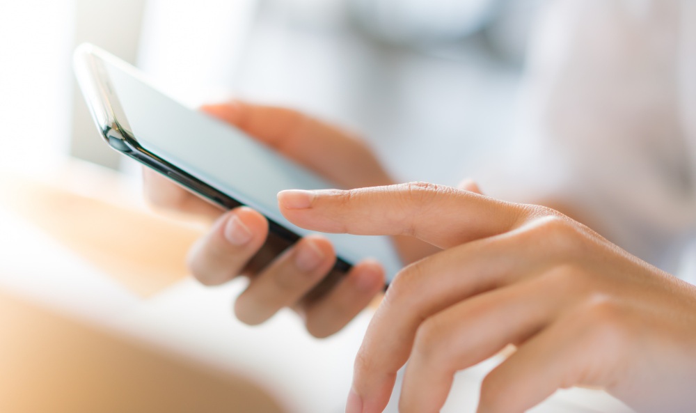 kobieta trzymająca telefon w dłoniach