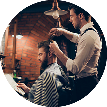 fryzjer strzyże klienta w salonie 