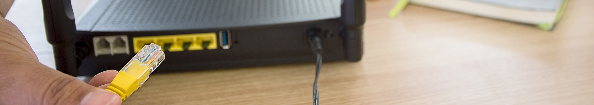 Dłoń wpinająca kabel sieciowy do routera